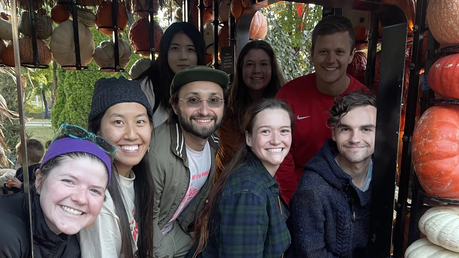 ESGP Students framed by a window made of pumpkins at Franklin Park Conservatory's 'Pumpkins Aglow' event